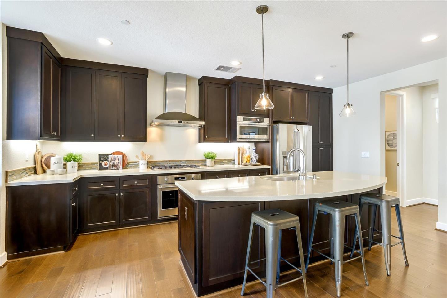 402 Neves Road San Mateo, CA 94403 - Photo 7 of 31 a kitchen with stainless steel appliances granite countertop wooden floor a stove a sink dishwasher and a refrigerator