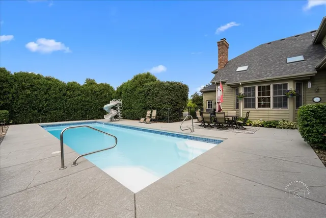 a view of a patio with swimming pool and table and chairs