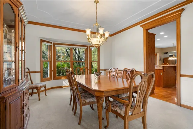 a dining room with furniture a chandelier and a rug
