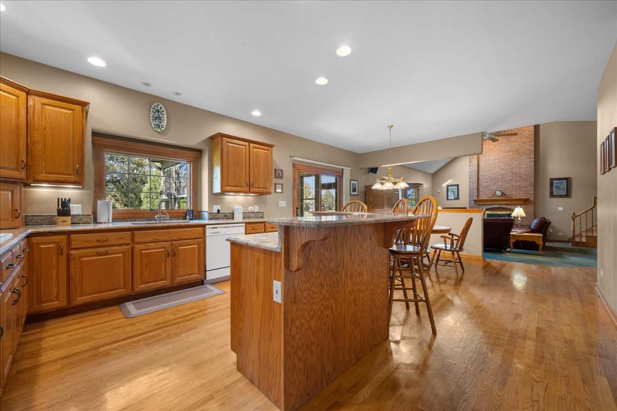 36W824 Red Gate Court St. Charles, IL 60175 - Photo 10 of 39 a kitchen with stainless steel appliances granite countertop a refrigerator a stove top oven and a dining table with wooden floor