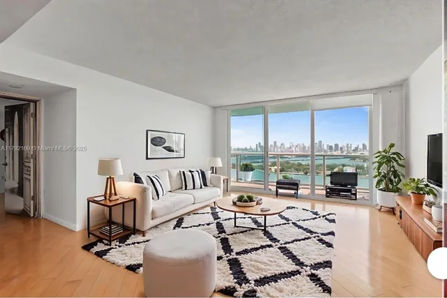 a living room with furniture large window and a table