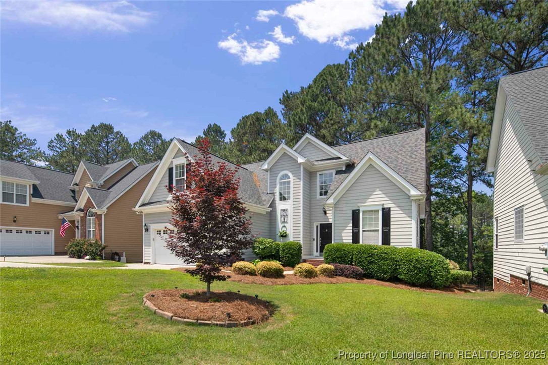 15 London Way Spring Lake, NC 28390 - Photo 3 of 46 a front view of a house with a yard and garage