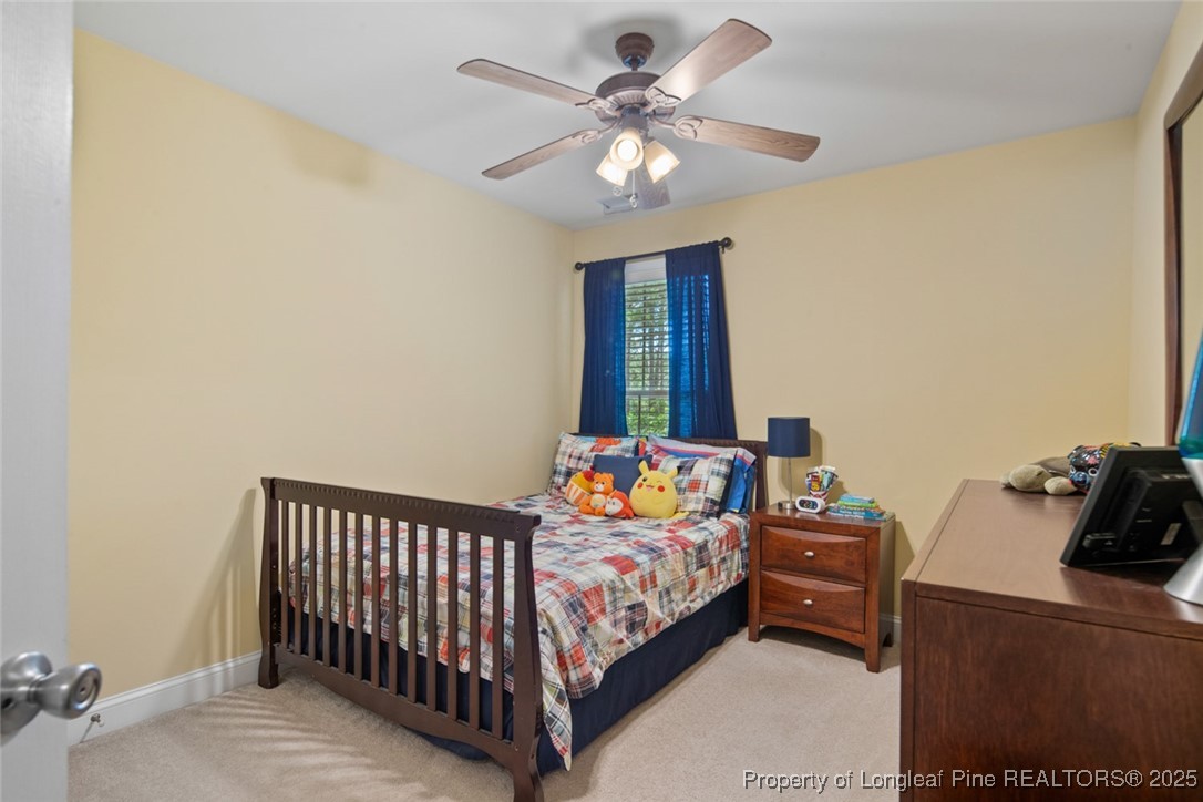 15 London Way Spring Lake, NC 28390 - Photo 36 of 46 a bedroom with a bed and a chandelier