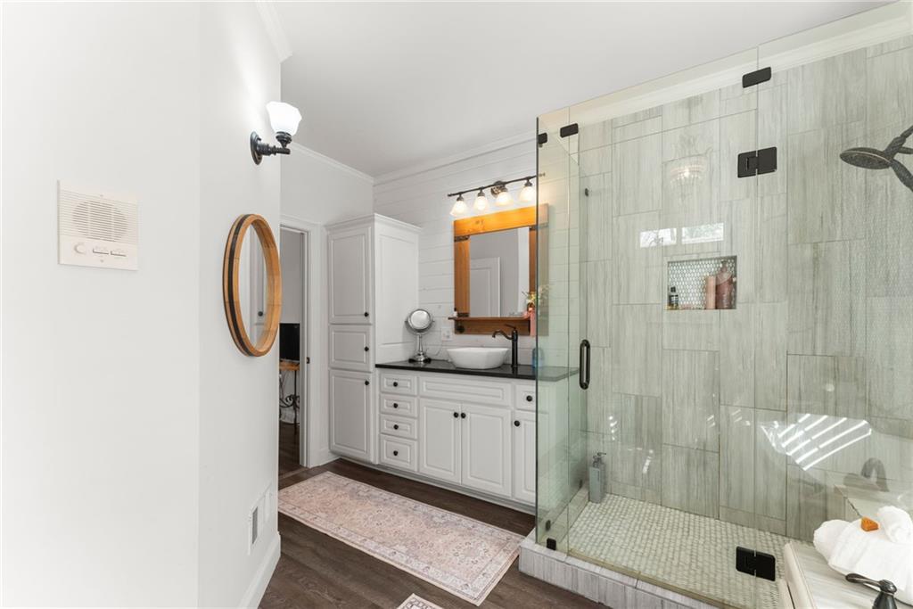 2195 East Maddox Road Buford, GA 30519 - Photo 24 of 100 a bathroom with a mirror a double vanity sink and glass door