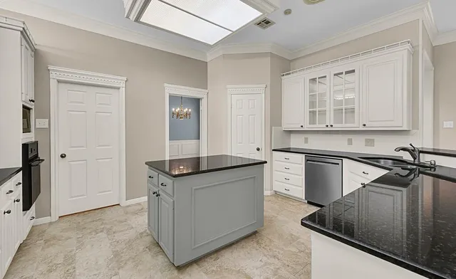 a kitchen with granite countertop a sink and cabinets
