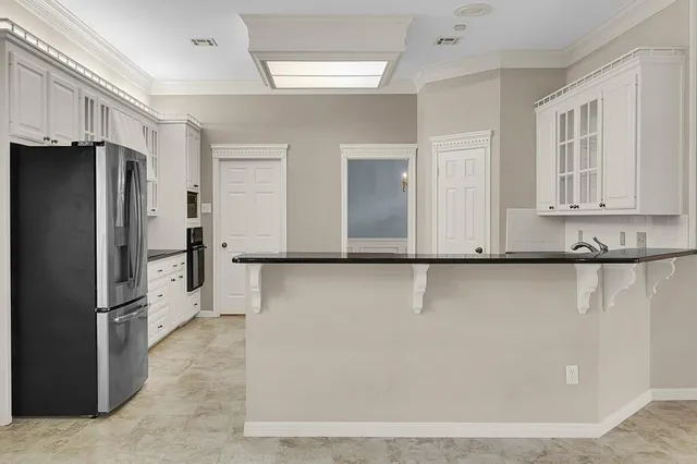 a view of a refrigerator in kitchen and a white cabinets
