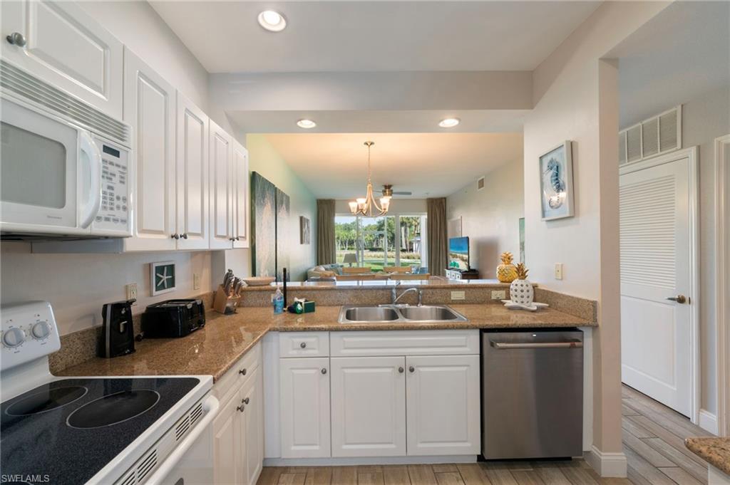 7940 Mahogany Run Lane, Unit 612 Naples, FL 34113 - Photo 13 of 25 a kitchen with stainless steel appliances granite countertop a sink stove and cabinets