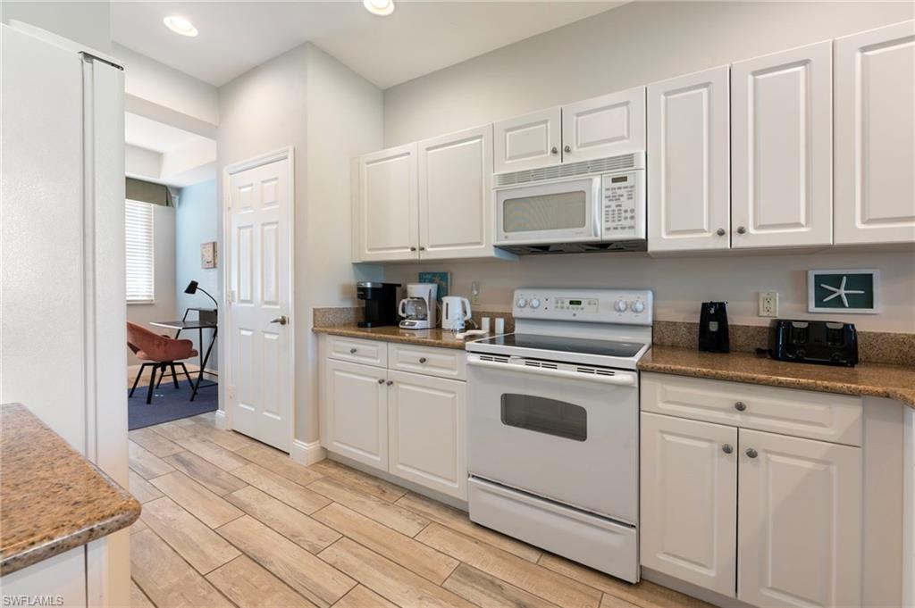 7940 Mahogany Run Lane, Unit 612 Naples, FL 34113 - Photo 15 of 25 a kitchen with stainless steel appliances granite countertop a sink a stove and cabinets