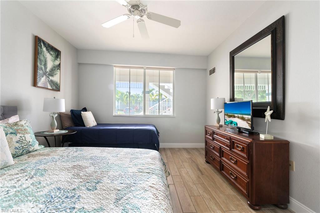 7940 Mahogany Run Lane, Unit 612 Naples, FL 34113 - Photo 5 of 25 a bedroom with a bed and wooden floor