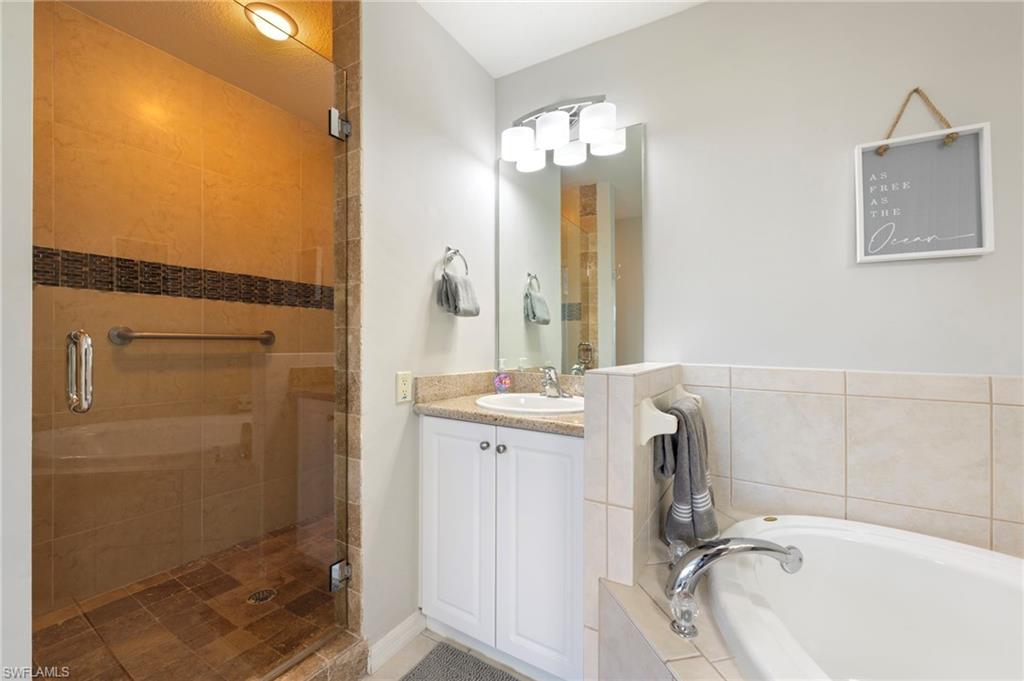 7940 Mahogany Run Lane, Unit 612 Naples, FL 34113 - Photo 7 of 25 a bathroom with a tub sink and mirror
