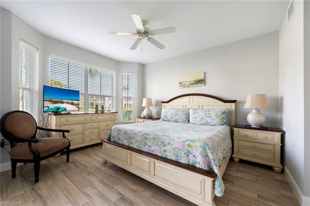 7940 Mahogany Run Lane, Unit 612 Naples, FL 34113 - Photo 10 of 25 a bedroom with a bed and wooden floor