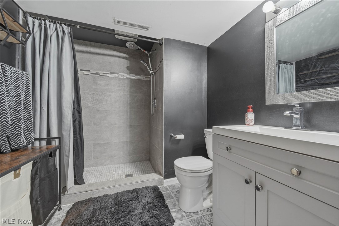 702 Perry Drive Northwest Canton, OH 44708 - Photo 16 of 46 Full bath featuring vanity, a shower stall, and light tile patterned floors