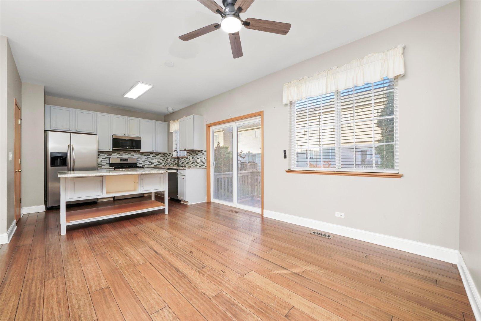 409 Evergreen Circle, Unit 4 Gilberts, IL 60136 - Photo 6 of 42 a kitchen with granite countertop wooden floors and white cabinets