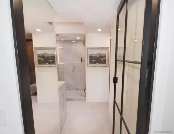 a spacious bathroom with a glass shower door and a sink