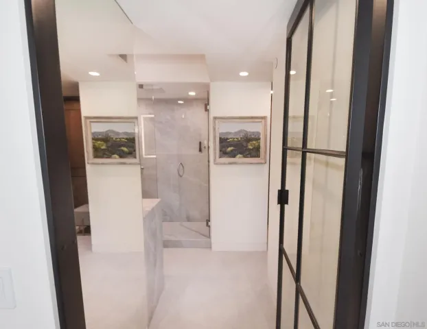 a spacious bathroom with a glass shower door and a sink