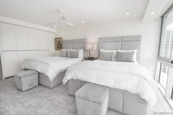 a bedroom with a large bed and a flat tv screen