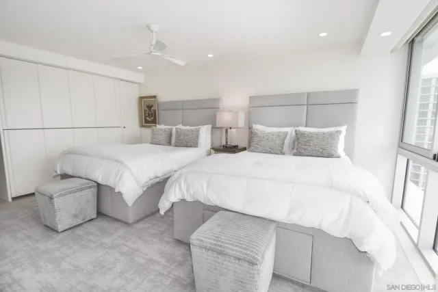 a bedroom with a large bed and a flat tv screen