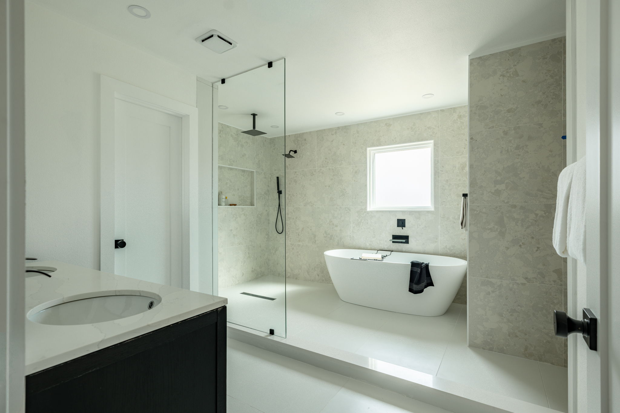 2201 Trede Drive Austin, TX 78745 - Photo 27 of 40 Full bath featuring vanity, a soaking tub, a tile shower, and tile walls