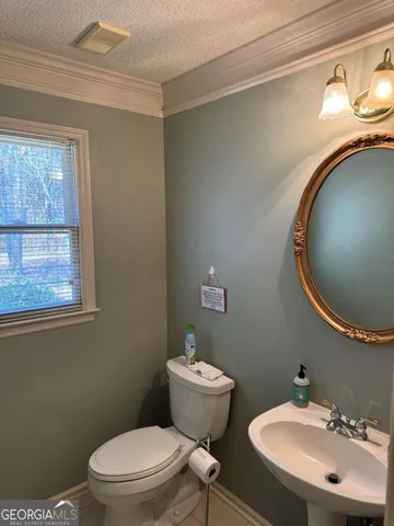 a bathroom with a toilet a sink and mirror