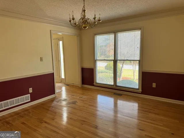 a view of room with window and wooden floor