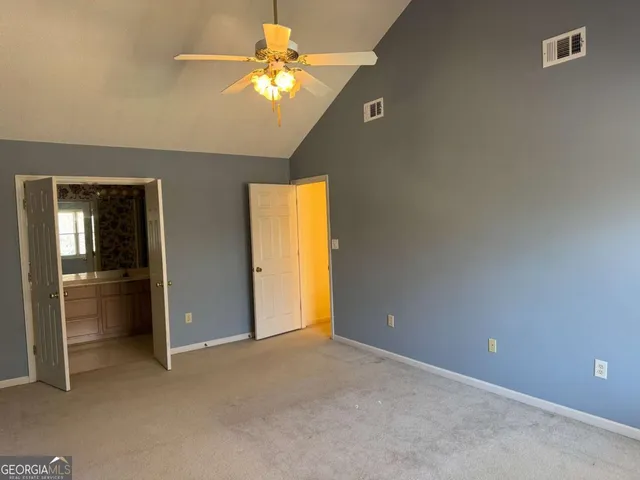 an empty room with closet and a chandelier fan