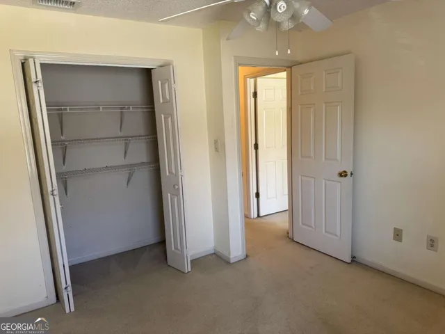 an empty room that has a large window and kitchen view
