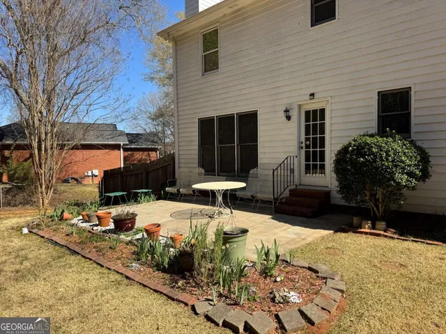 a view of a house with backyard and sitting area