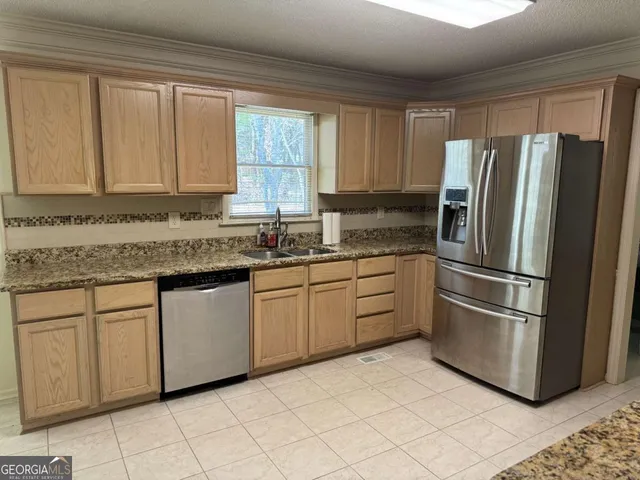 a kitchen with stainless steel appliances granite countertop a refrigerator sink and cabinets