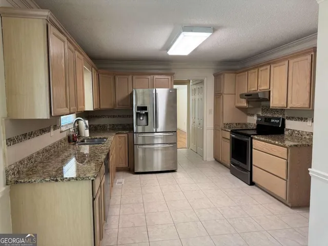 a kitchen with a refrigerator sink and cabinets