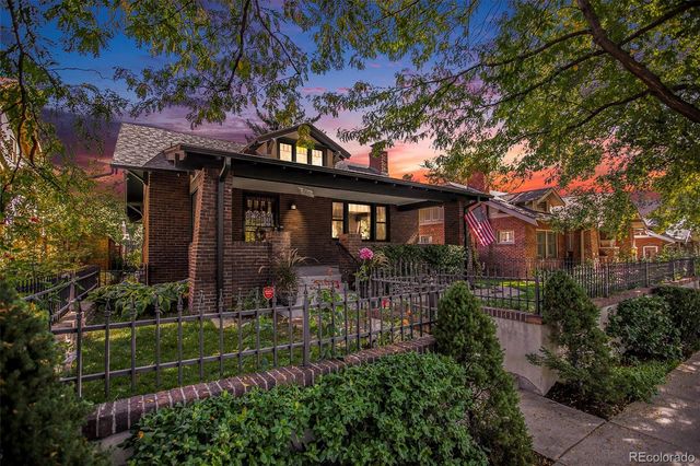 a view of house with a yard and potted plants