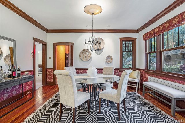 a view of a dining room with furniture a chandelier and wooden floor