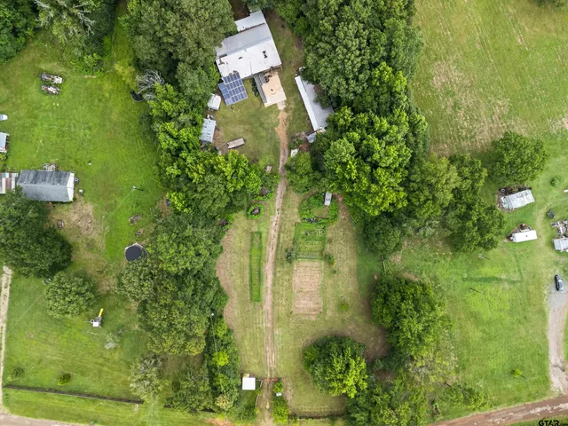 an aerial view of residential house with an outdoor space and seating