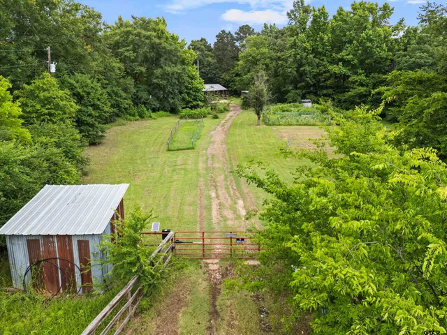 a view of house with yard and trees in the background