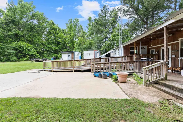 a view of a house with a patio and a yard