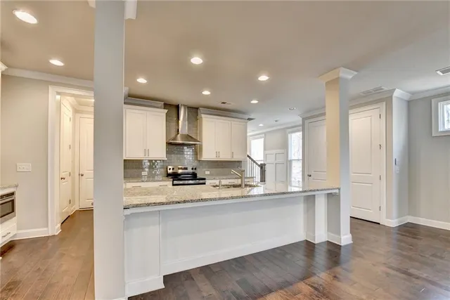 an empty room with wooden floor fireplace and windows
