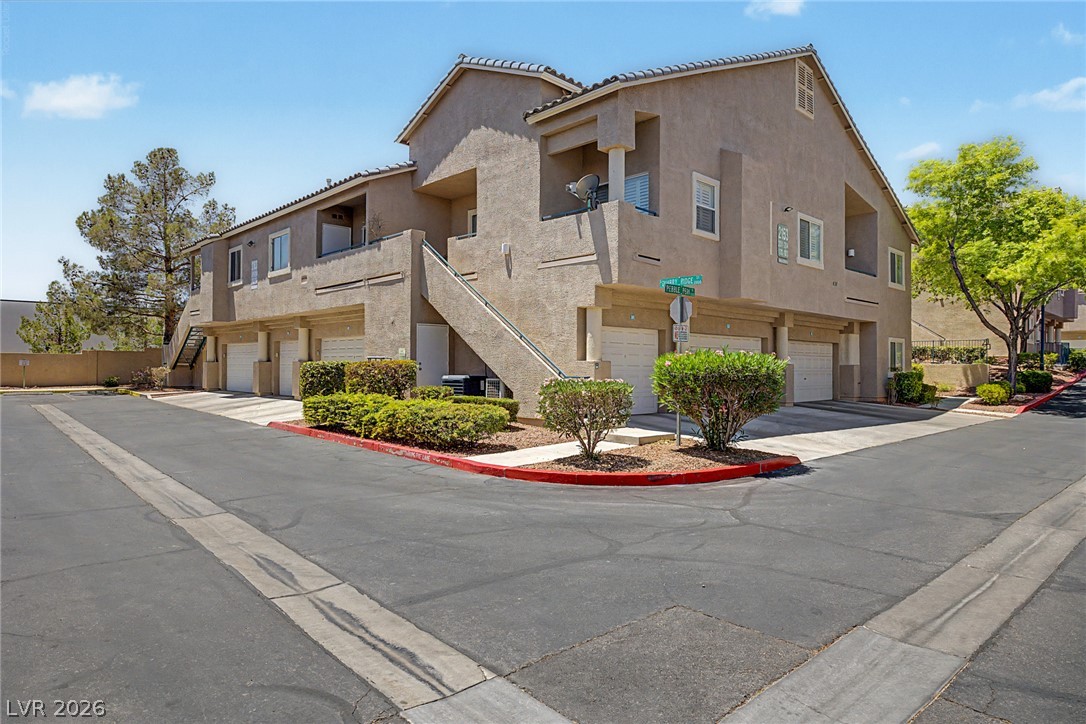 2153 Quarry Ridge Street, Unit 103 Las Vegas, NV 89117 - Photo 6 of 42 Multi-level residential building with well-maintained landscaping and attached garages.