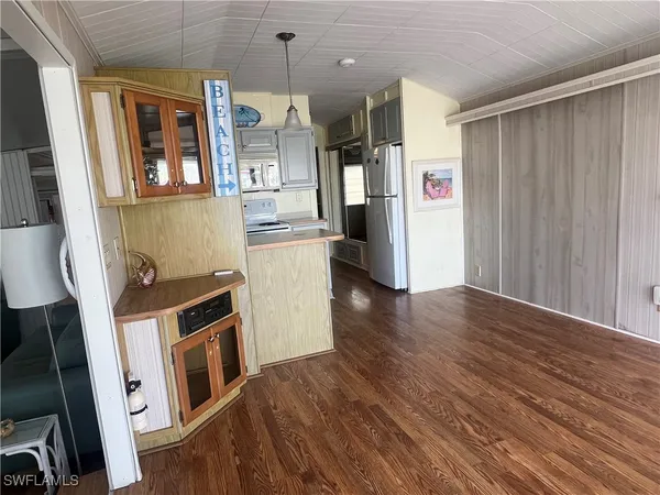 a view of a kitchen with refrigerator and wooden floor