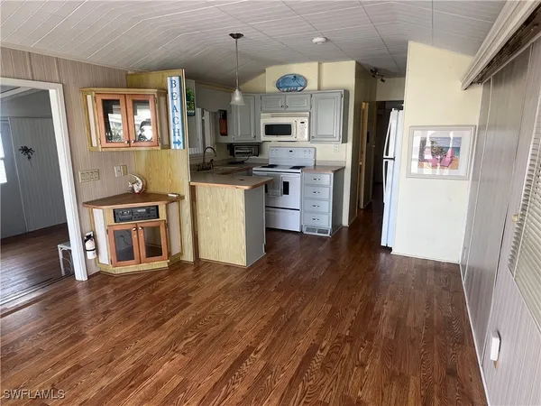 a kitchen with stainless steel appliances a refrigerator and wooden floor
