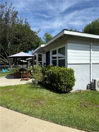 a view of a house with backyard sitting area and garden