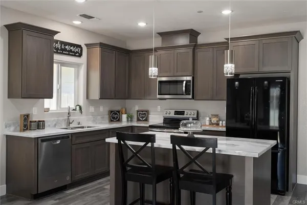 a kitchen with a table chairs refrigerator microwave and cabinets