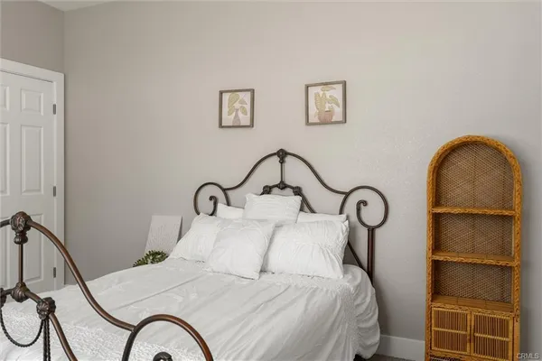a bedroom with a bed and a table with exposed radiator