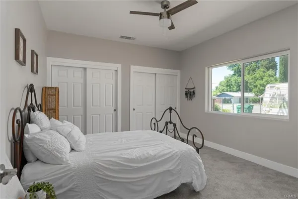 a bedroom with a bed next to a window