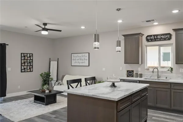 a bathroom with a granite countertop sink a large mirror and a potted plant
