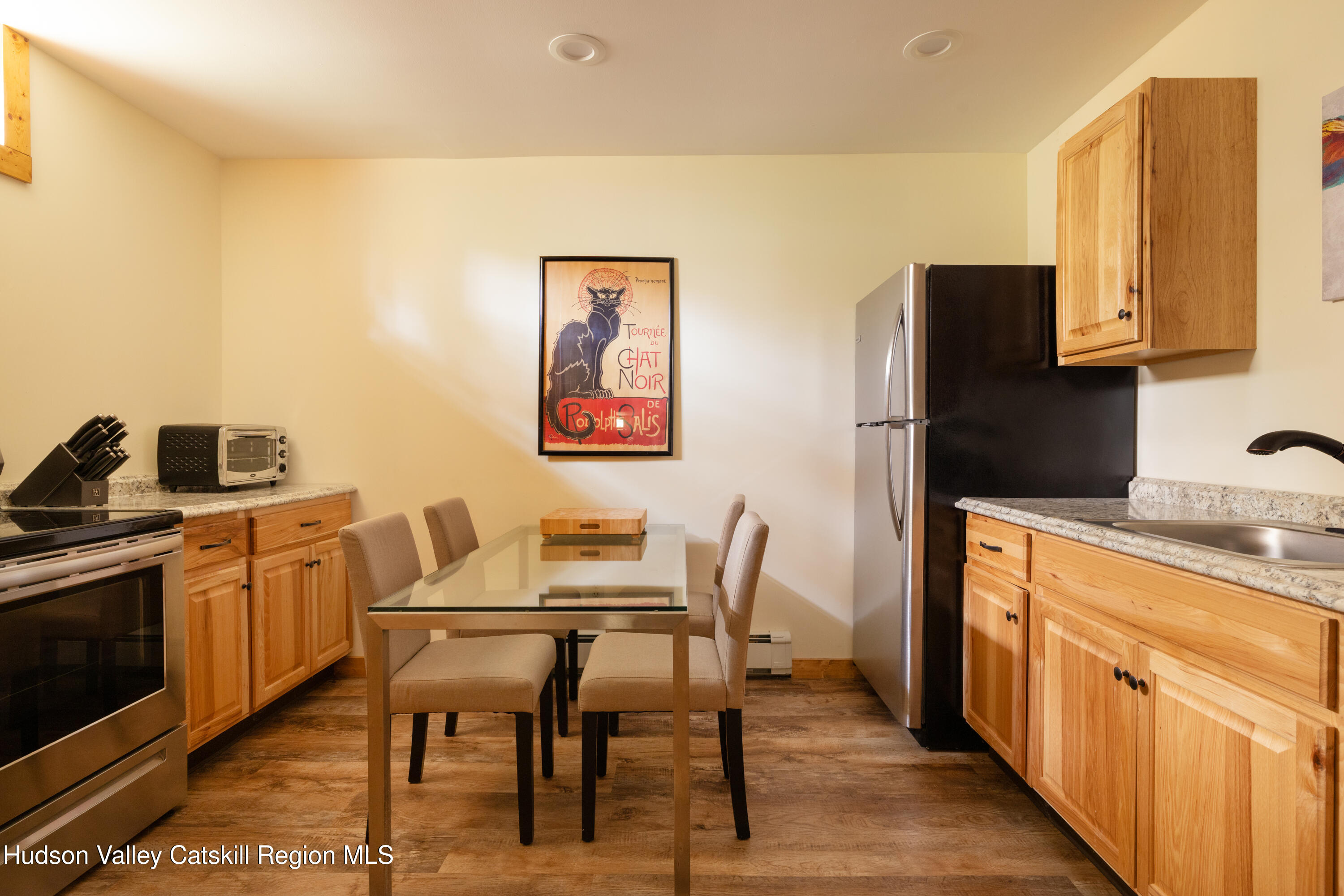 231 Decker Road Sparrowbush, NY 12780 - Photo 20 of 31 a kitchen with stainless steel appliances granite countertop a refrigerator a stove a sink a dining table and chairs with wooden floor