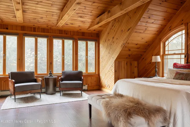 a bedroom with furniture and large windows