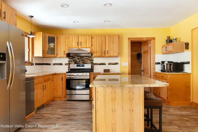 a kitchen with stainless steel appliances a stove a sink and a refrigerator