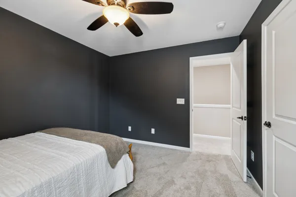 a bedroom with bed and a flat tv screen on dresser