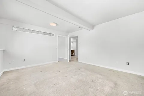 a view of an empty room with closet and a window