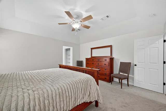 a bedroom with a bed dresser and a window