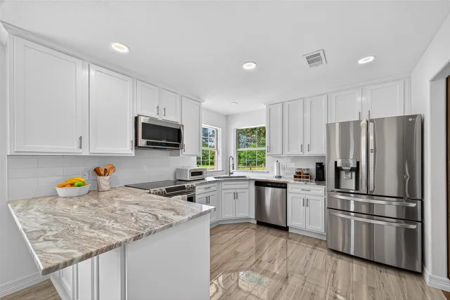 a kitchen with granite countertop stainless steel appliances and wooden cabinets